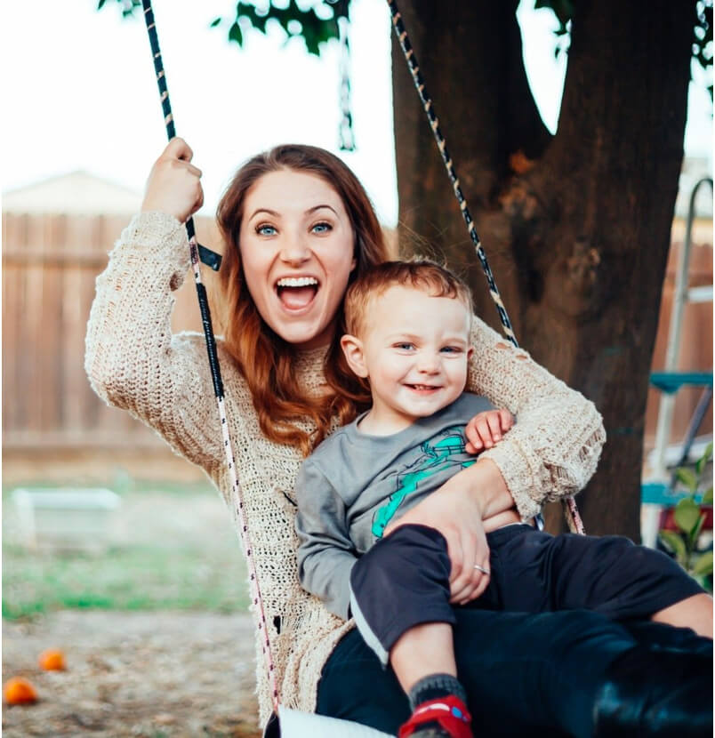 A woman smiling while holding her son after a dentist appointment in Uptown Dallas
